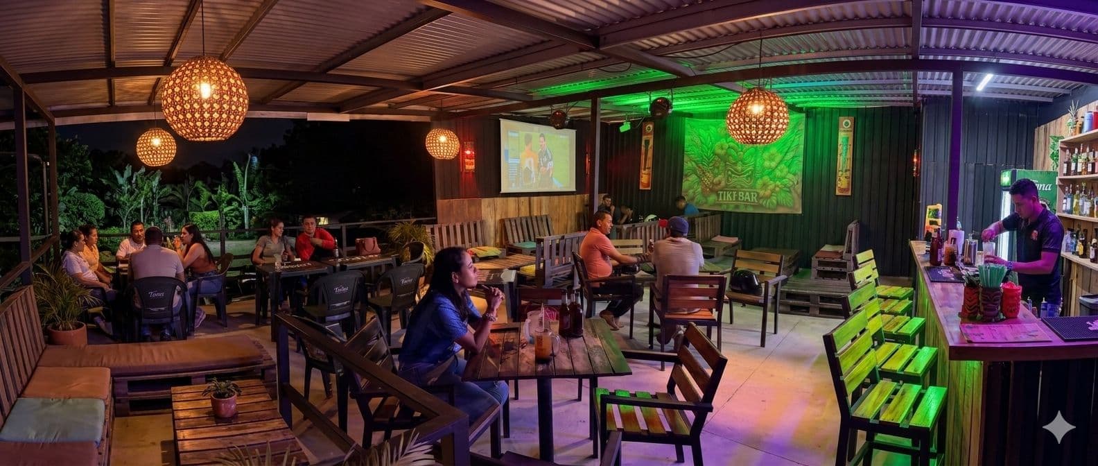 Barra y mesas de PicaDelis con ambiente nocturno